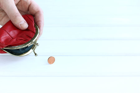 the last coin fell out of an open red wallet in his hand. onset of payment crisis