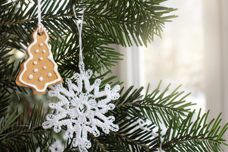 Christmas tree ginger figurine with icing on a background of evergreen branches. homemade Christmas...
