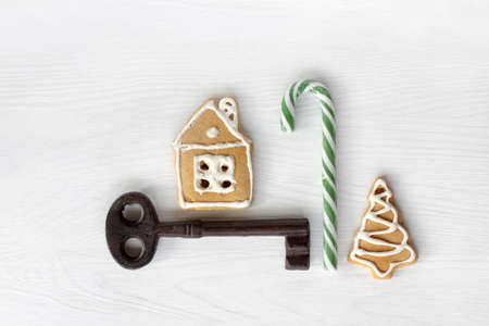 gingerbread house, ginger tree, candy staff and big retro key on the table top view. holiday apartments for the new yearの写真素材