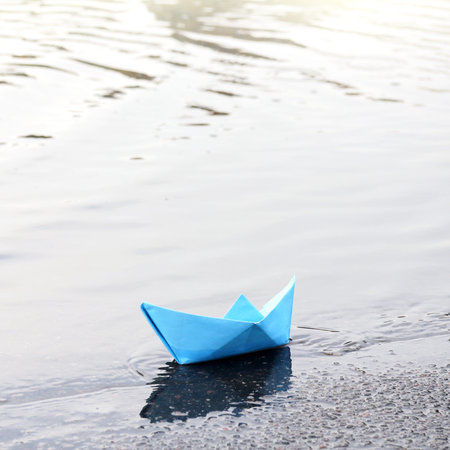 blue paper boat on the shore of the reservoir. waiting for a tailwindの写真素材