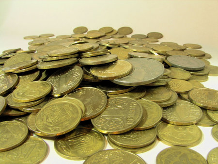 heap of coins lying on a table over white
