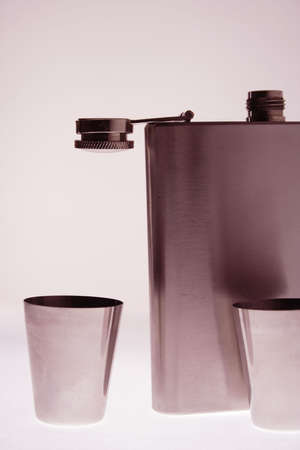 silver whisky flask with two drinks on a whiteの写真素材