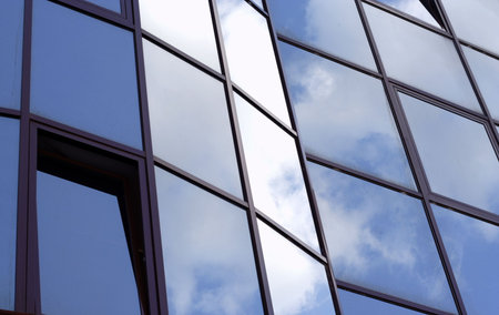 blue sky and clouds reflecting at the office building windows