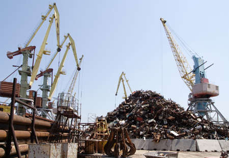 lot of port cranes and heap of scrap metalの写真素材
