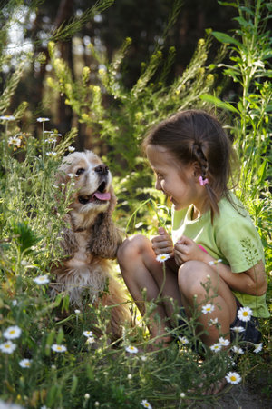 little girl sitting side by side with her dogの写真素材