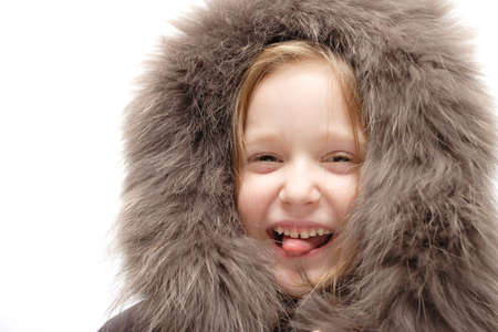 smiling child in a winter fur hoodの写真素材