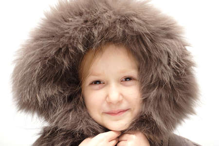smiling child in a winter fur hoodの写真素材
