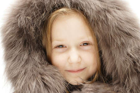 smiling child in a winter fur hoodの写真素材