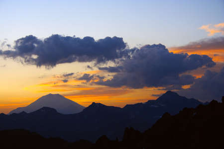 raising sun beams illuminating an Elbrus mountainsideの写真素材