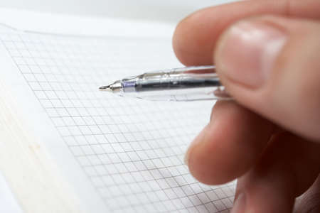 man`s hand holding a pen and ready to writing at the notebookの写真素材