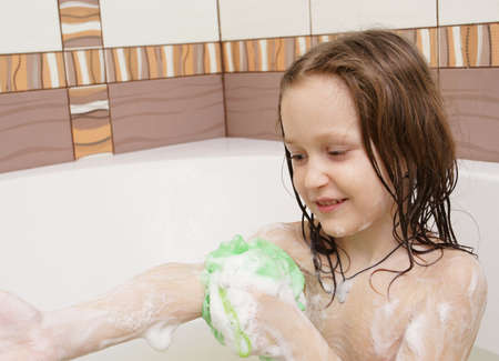 smiling little child covered with a soap at the bathの写真素材