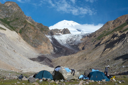 hikers resting near the tent at the mountain camp