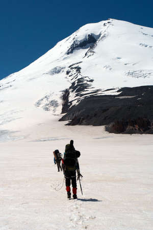 climbers walking up by the snowed glacier to the high summitの写真素材