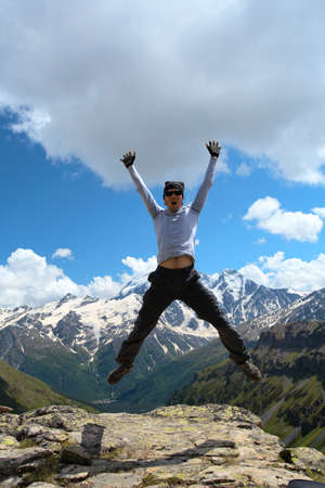 jumping hiker and mountains with blue sky in the background
の写真素材