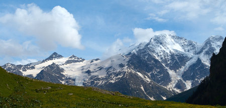 wide green valley with snowed peaks in the distance