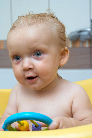 smiling little baby girl covered with a soap at the bath