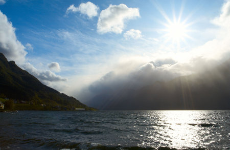 beams of bright sun shining over the water of norwegian fjord