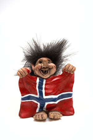 figurine of smiling troll hanging a flag at his arms isolated on a white, norwayの写真素材