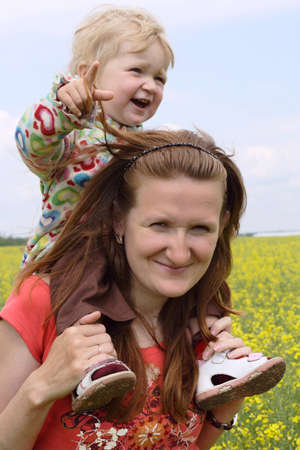 smiling child sitting on a mother shoulders walking at the field
の写真素材