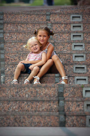 two sisters looking at the camera outdoor .の写真素材