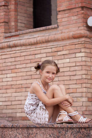 little smiling girl lying on a stairs of urban building.の写真素材