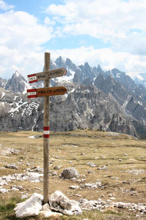 Alpine hiking trails hint along a trail, on background high rocky mountains, Italyの写真素材