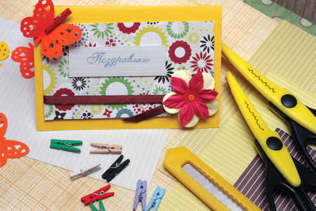hand made scrapbooking post card and tools lying on a tableの写真素材