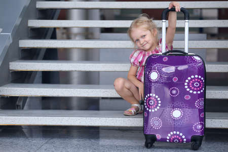 girl and suitcase at the airportの写真素材