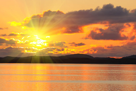 bloody sunset over the sea and mountains peaks