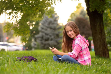 Girl with notebook sitting at  the grass
の写真素材