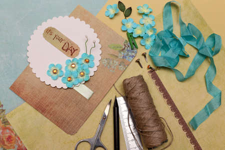 hand made scrapbooking post card and tools lying on a tableの写真素材