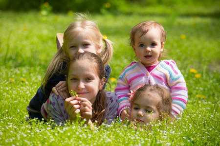 four girls lying on grass outdoorsの写真素材