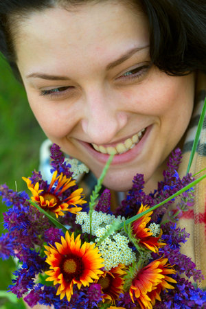girl with  bouquet of  salvia and camomileの写真素材