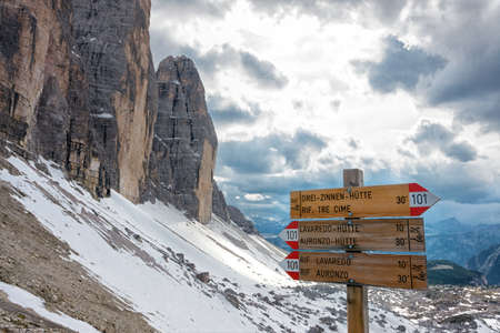 Alpine hiking trails hint along a trail, on background high rocky mountains, Italyの写真素材
