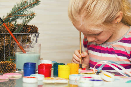 little girl draws sitting at the tableの写真素材