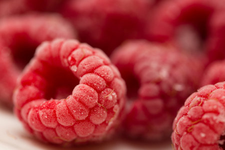 background made of frozen raspberries close up