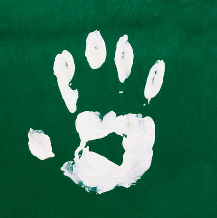 white paints children fingerprints  on a multicolored backgroundの写真素材