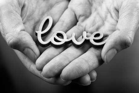 hands holding word love  black on whiteの写真素材