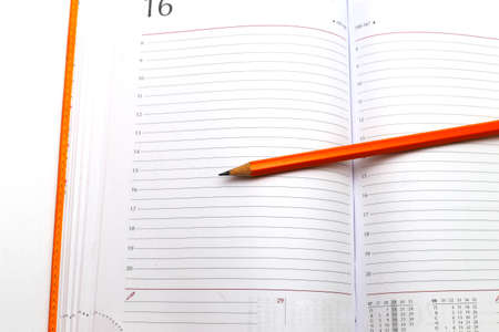 Opened notepad and pencil on a white close up shootの写真素材