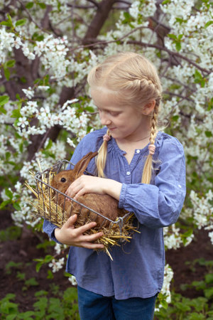 little girl with a rabbit in the garden, spring