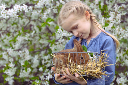 little girl with a rabbit in the garden, spring