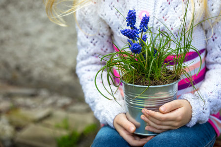 girl holding flowers hyacinths  in a pot