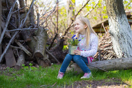 smiling girl holding flowers hyacinths  in a potの写真素材