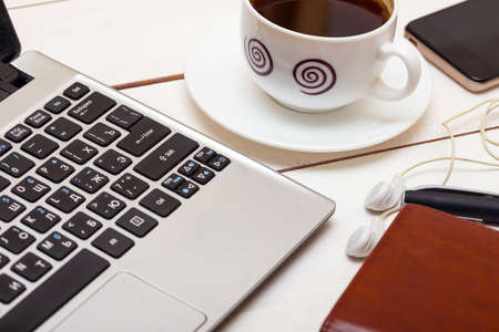 laptop and a cup of coffee, headphones, notebook, phoneの写真素材