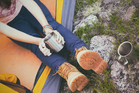 girl hiker in a tent and holding a cupの写真素材