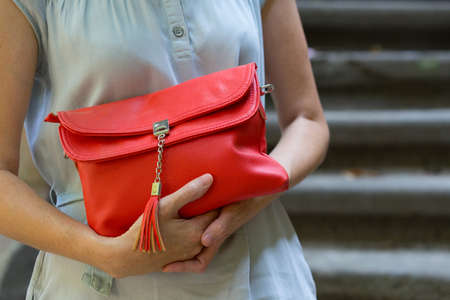 girl holding a beautiful red klutch outdoorsの写真素材