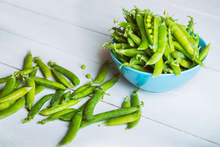 Fresh green peas on a wooden tableの写真素材