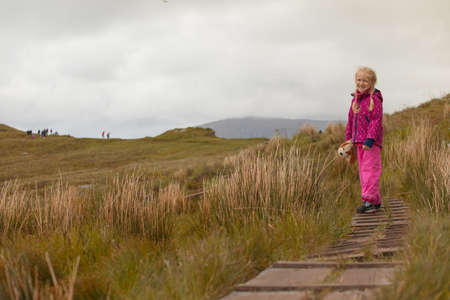 smile little girl walking along the trail in the Norwegian mountains, runde, Norwayの写真素材