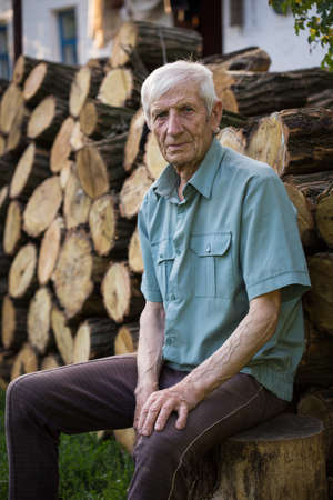 senior man sitting near his rural houseの写真素材