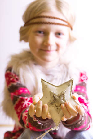 Christmas - children's hands girl holding a star and smilingの写真素材